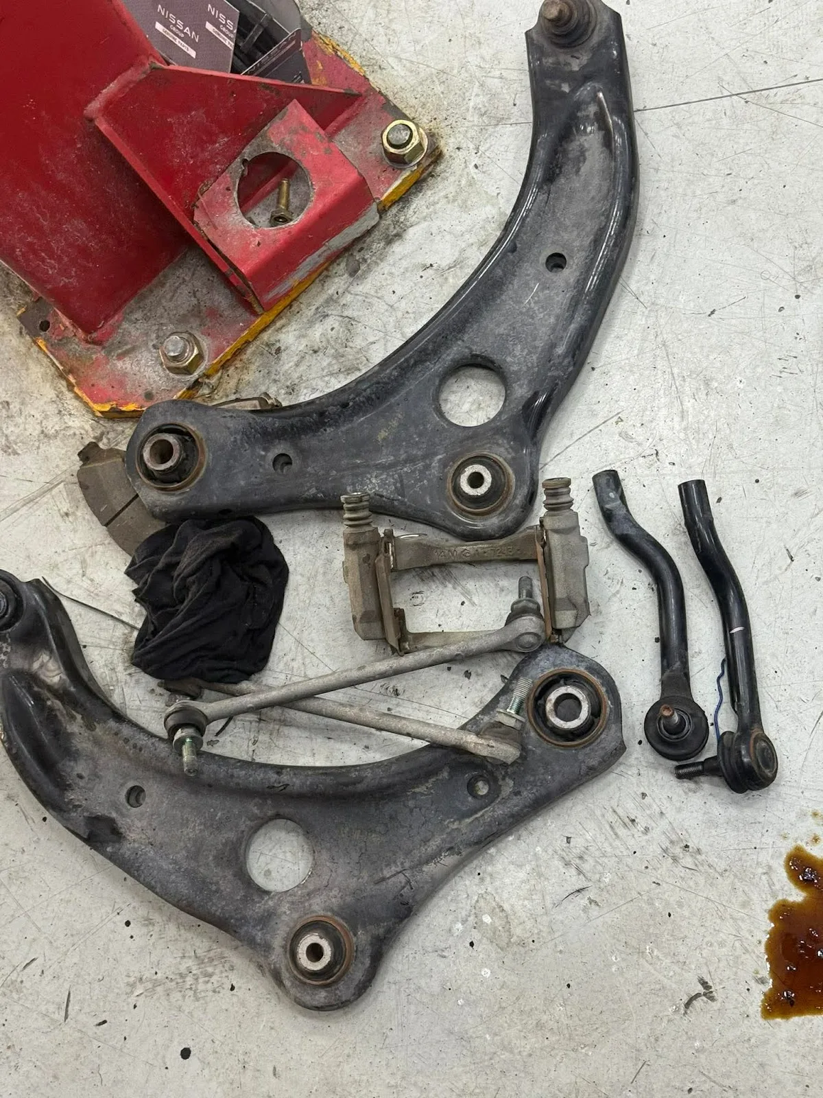 Suspension arms and steering components laid out for replacement