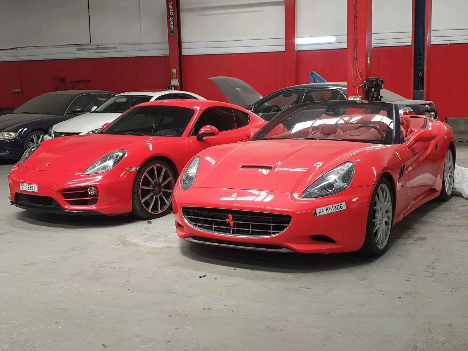 Red Ferrari and Porsche in the workshop