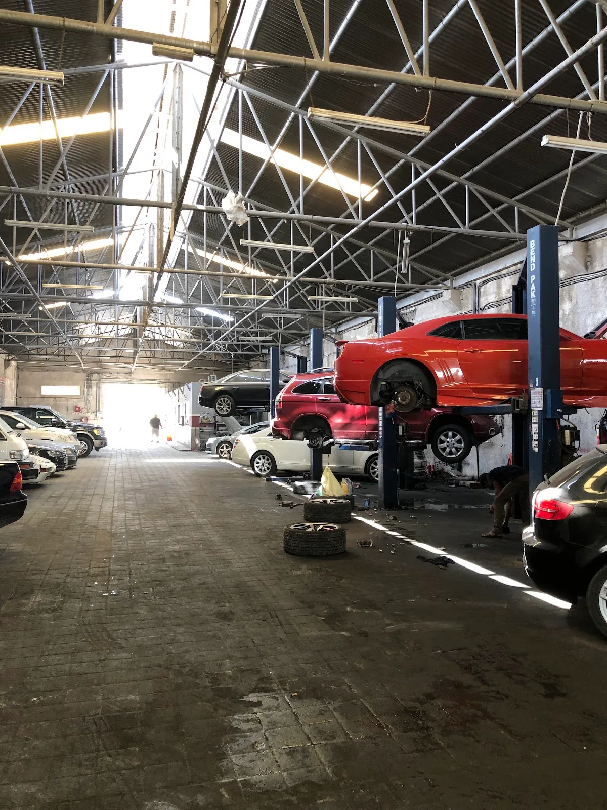 Cars raised on lifts inside the VIP German Auto Repairing workshop