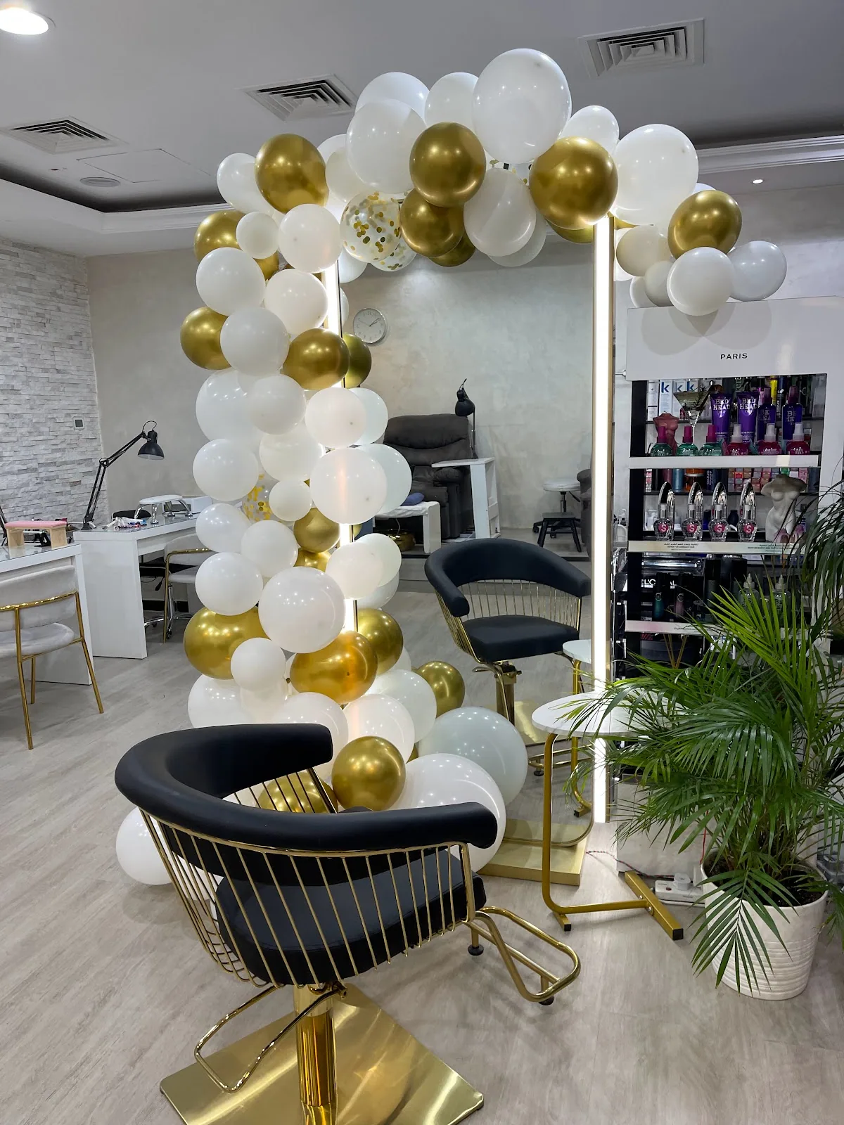 Vesna Beauty Lounge styling area with gold-and-black chairs and a soft décor arch