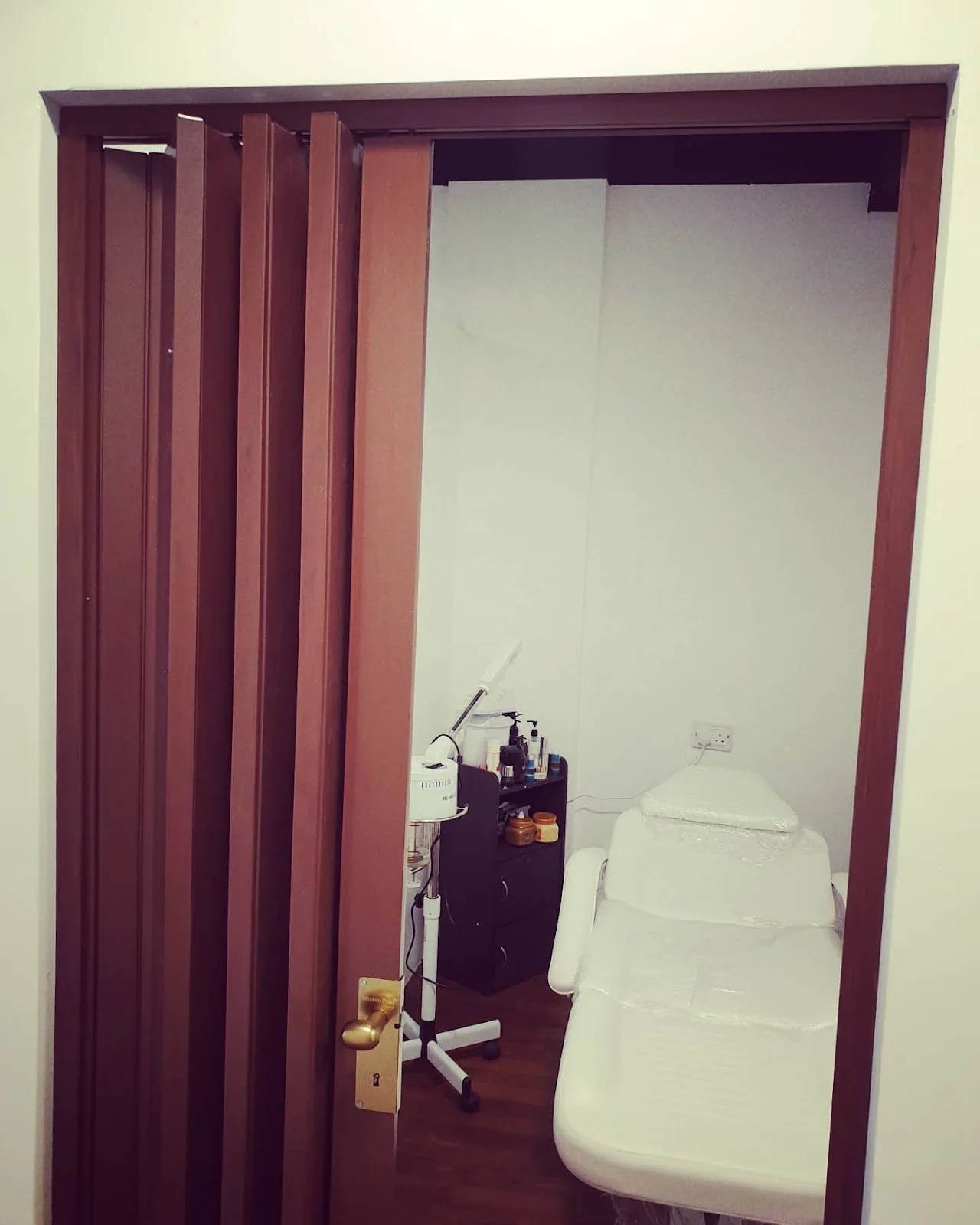 Private facial treatment room with a clean white bed inside the salon