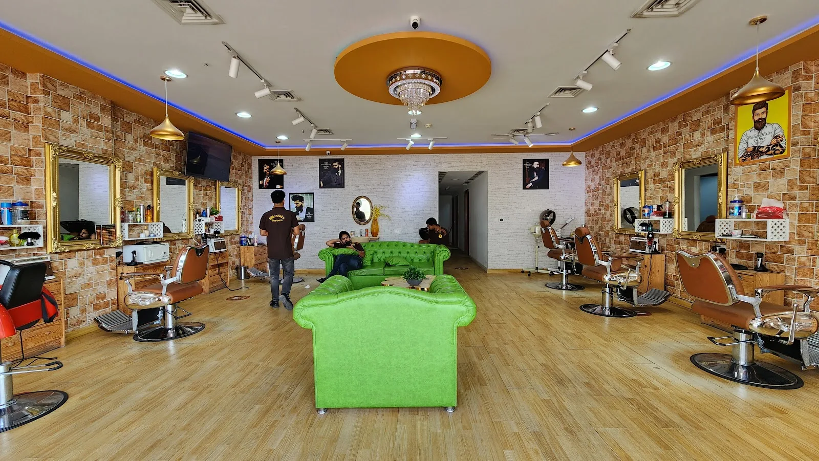 Interior of The BillionHairs Barber Shop — gold-framed mirrors, vintage barber chairs and green chesterfield lounge seating
