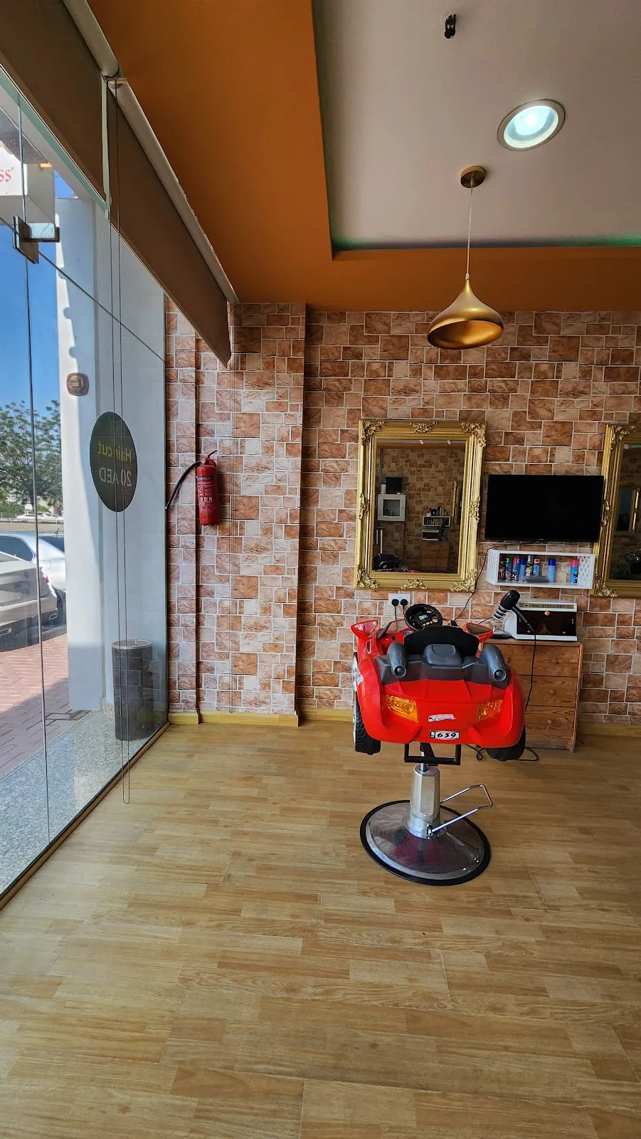 Kids barber station with a red toy-car styling chair and gold mirror