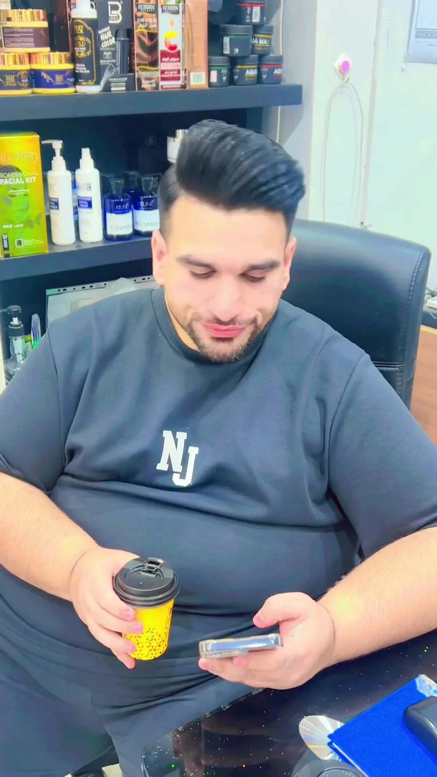 Client with a freshly styled pompadour beside the salon's hair-care product shelf