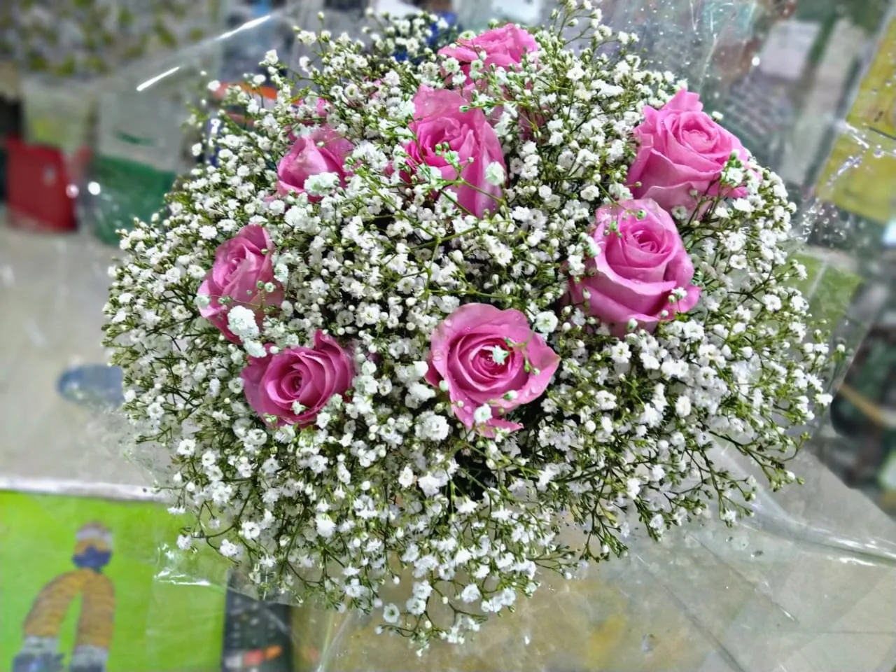 Round bouquet of pink roses surrounded by baby's breath