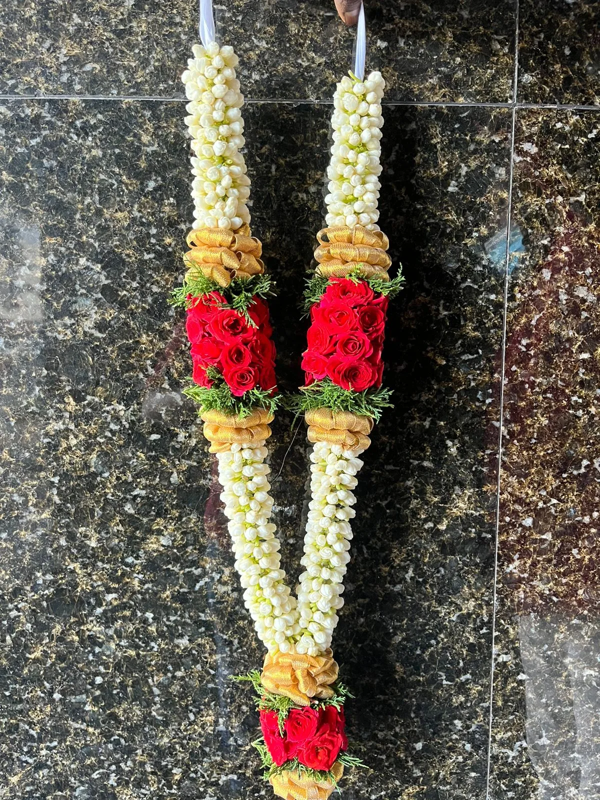 Pair of white jasmine garlands with red roses and gold ribbon accents