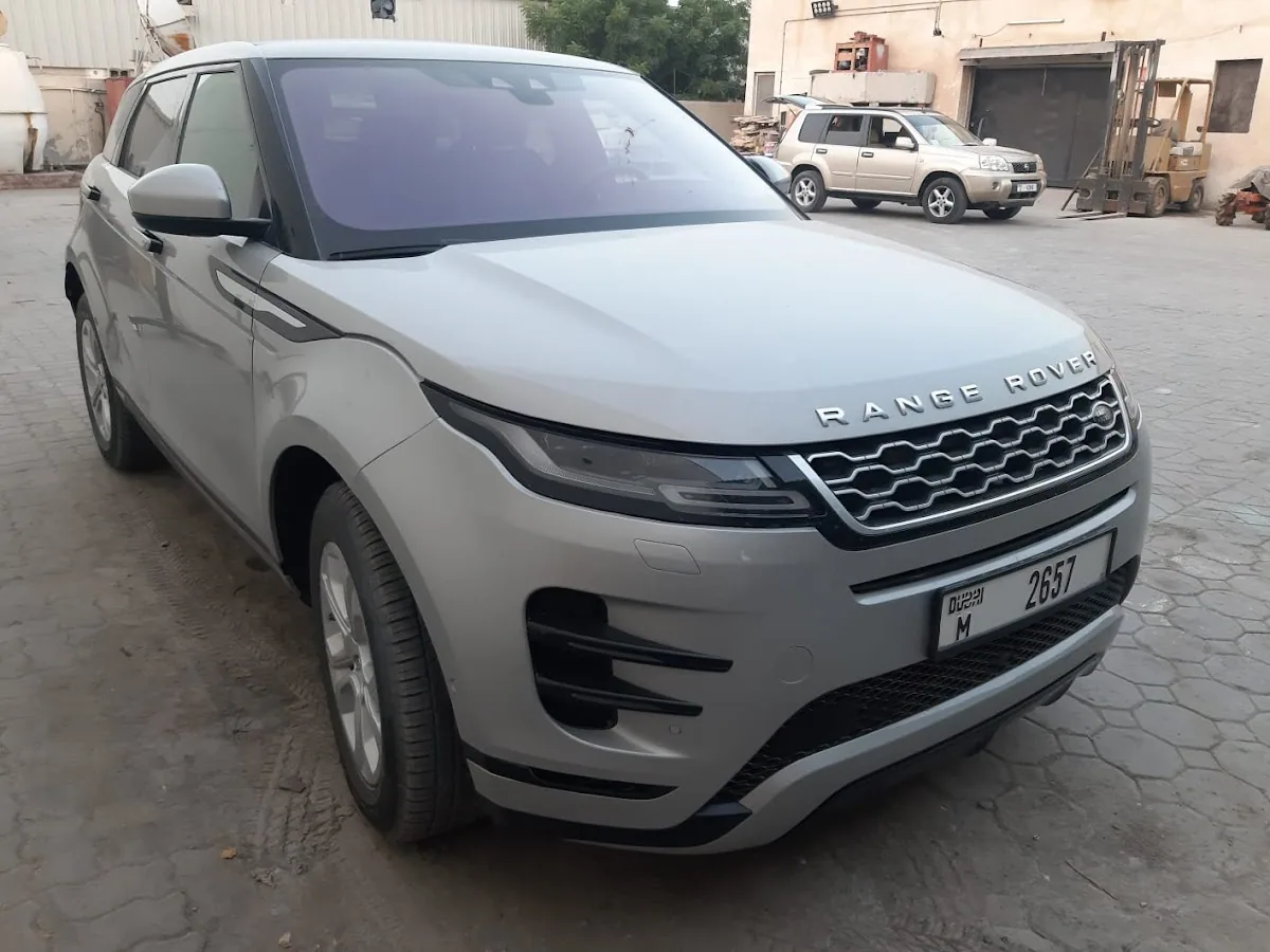 A silver Range Rover Evoque finished and ready for collection outside the garage