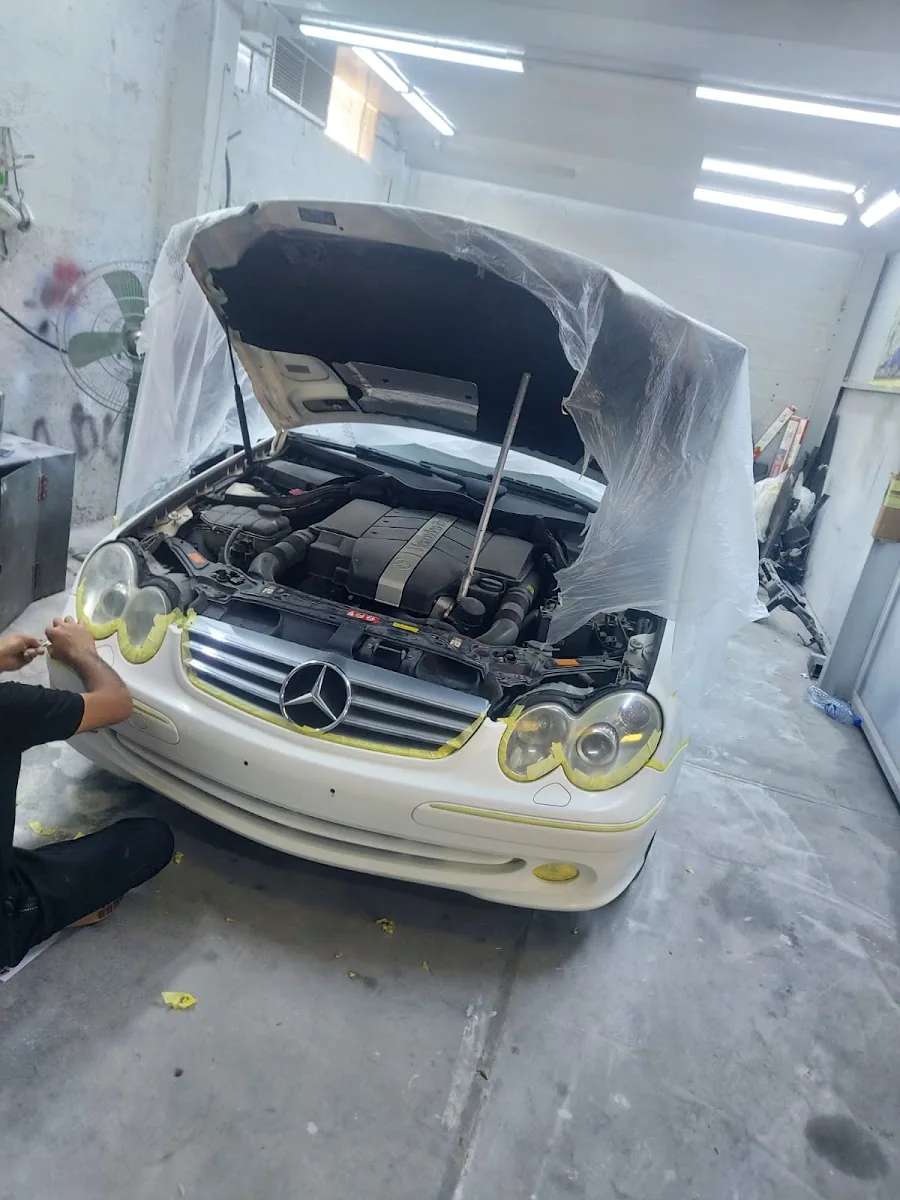 A white Mercedes masked up in the paint booth at Man City Garage