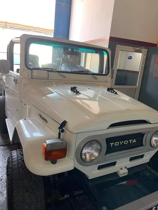 A restored classic white Toyota Land Cruiser inside the workshop