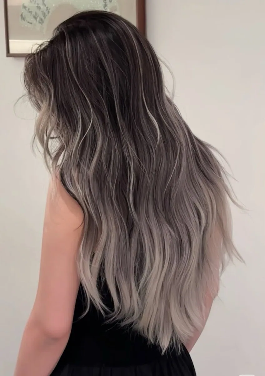 Long wavy hair with a smoky ash-to-silver balayage blend