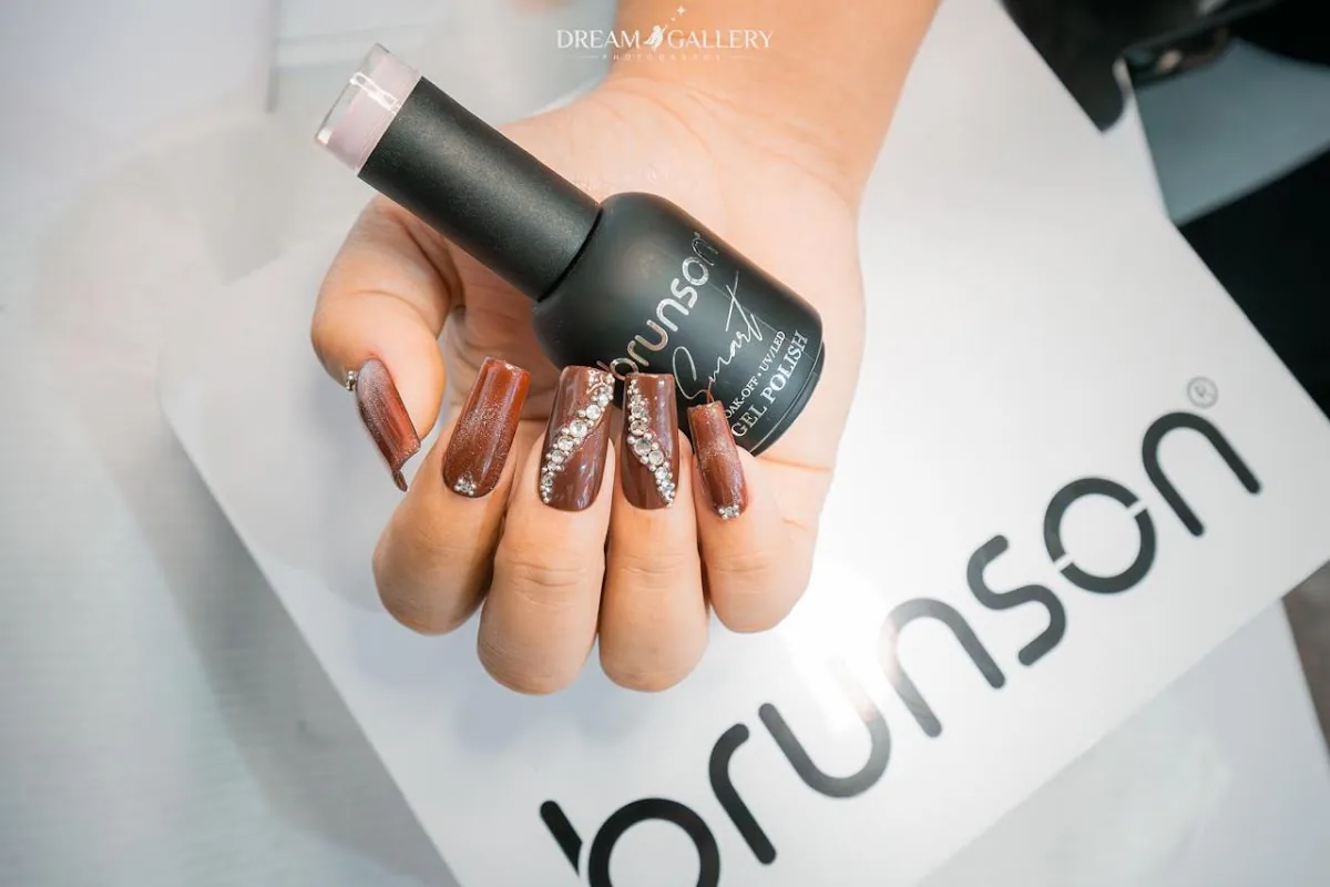 Glossy brown gel nails with rhinestone detailing