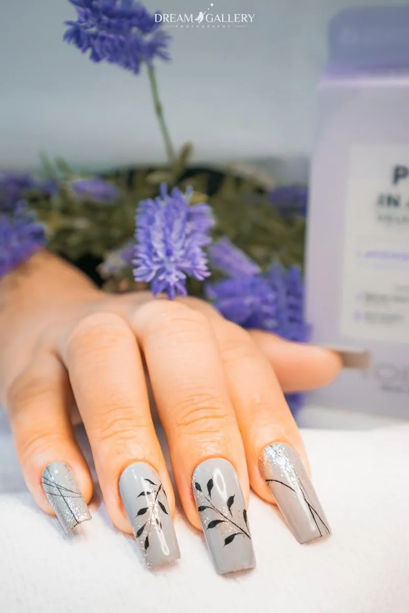 Grey gel nails with delicate black leaf line art