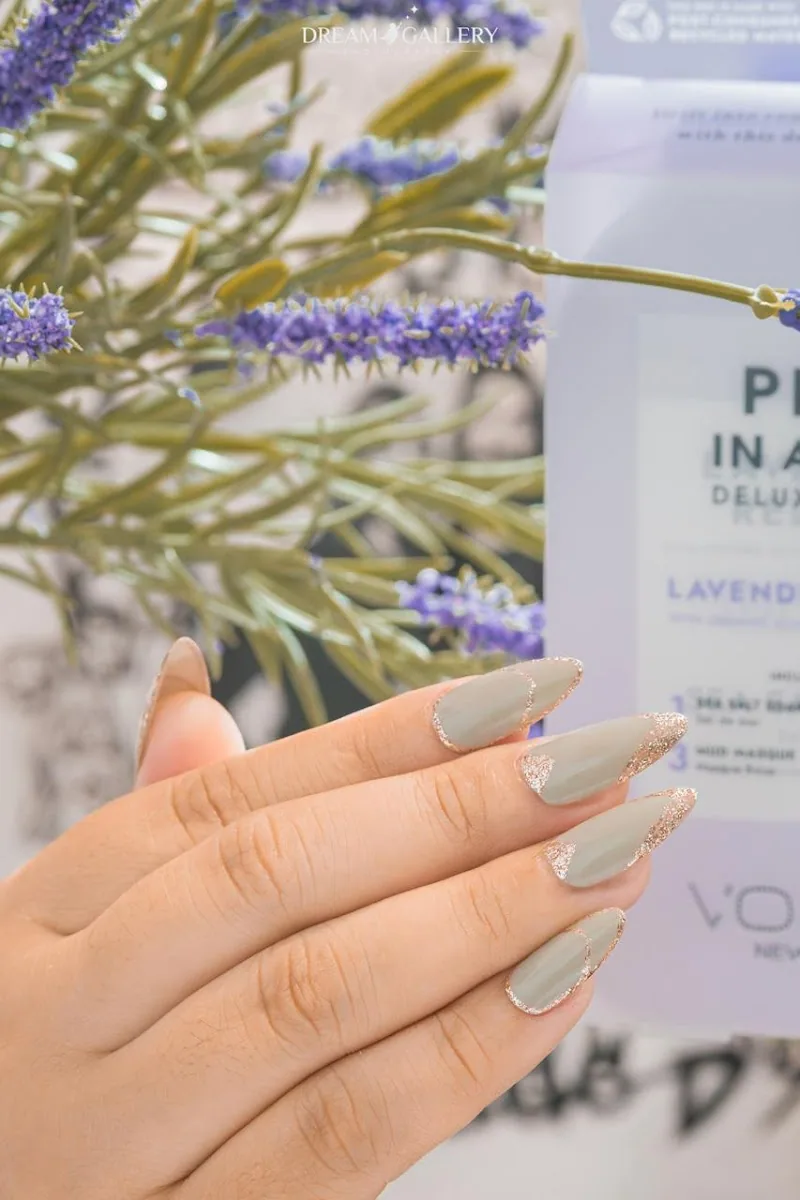 Sage green almond nails with gold glitter french tips