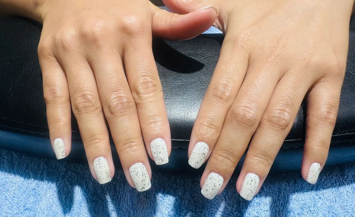 Short square white nails with a fine speckled finish