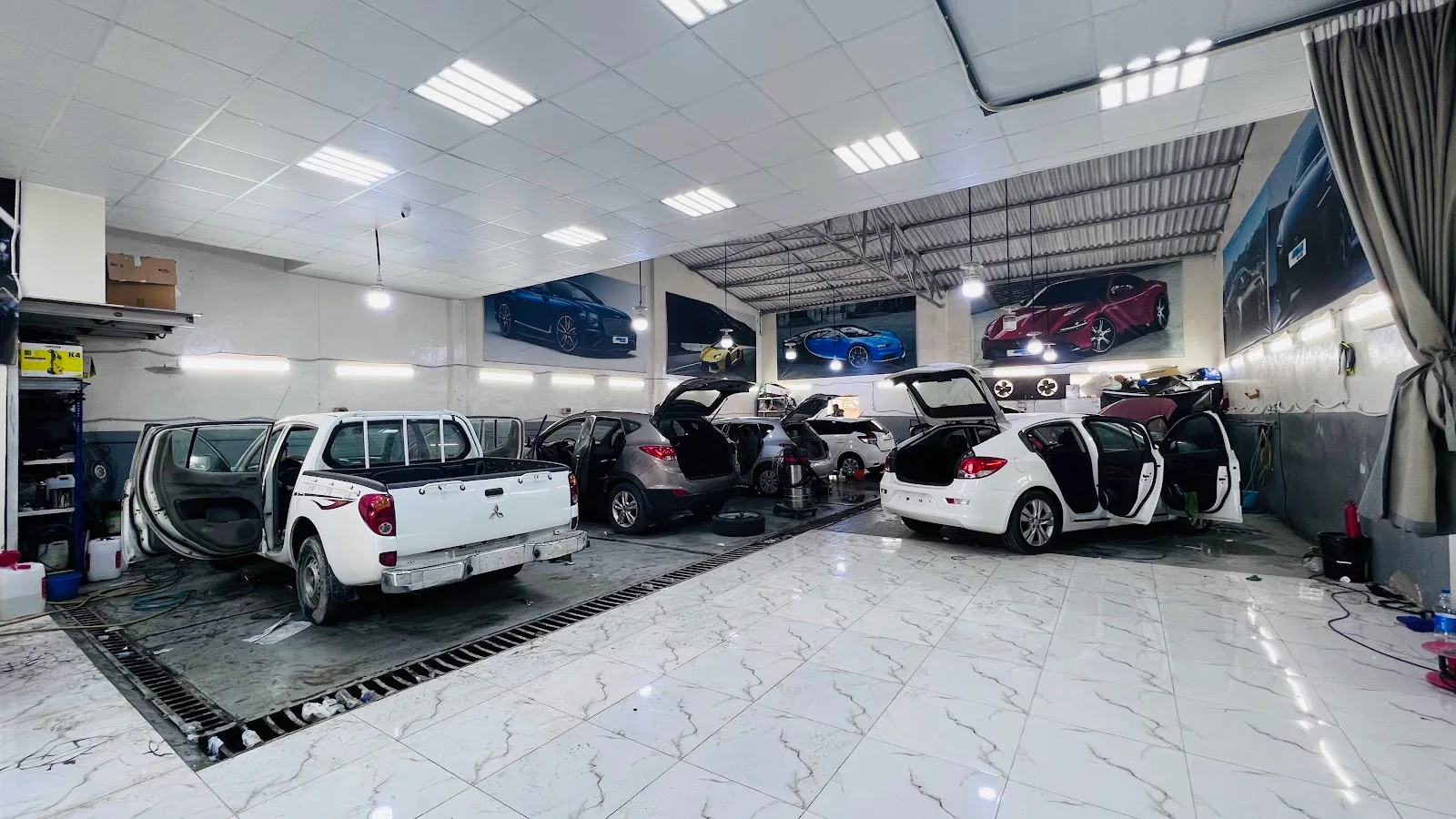 The HUMAID CAR CARE workshop floor in Ras Al Khor with several cars being detailed
