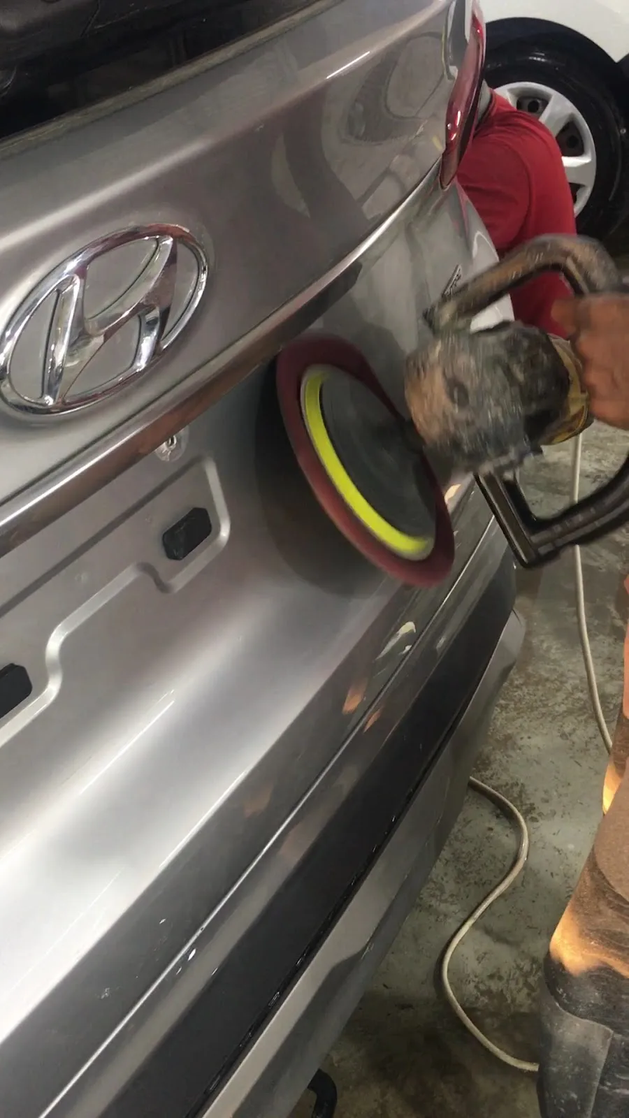 Machine polishing the rear panel of a car