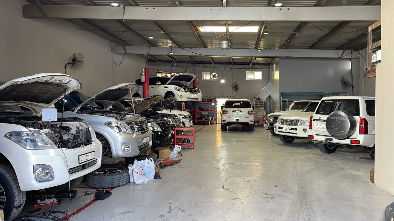 Wide view of the workshop with a row of SUVs under service