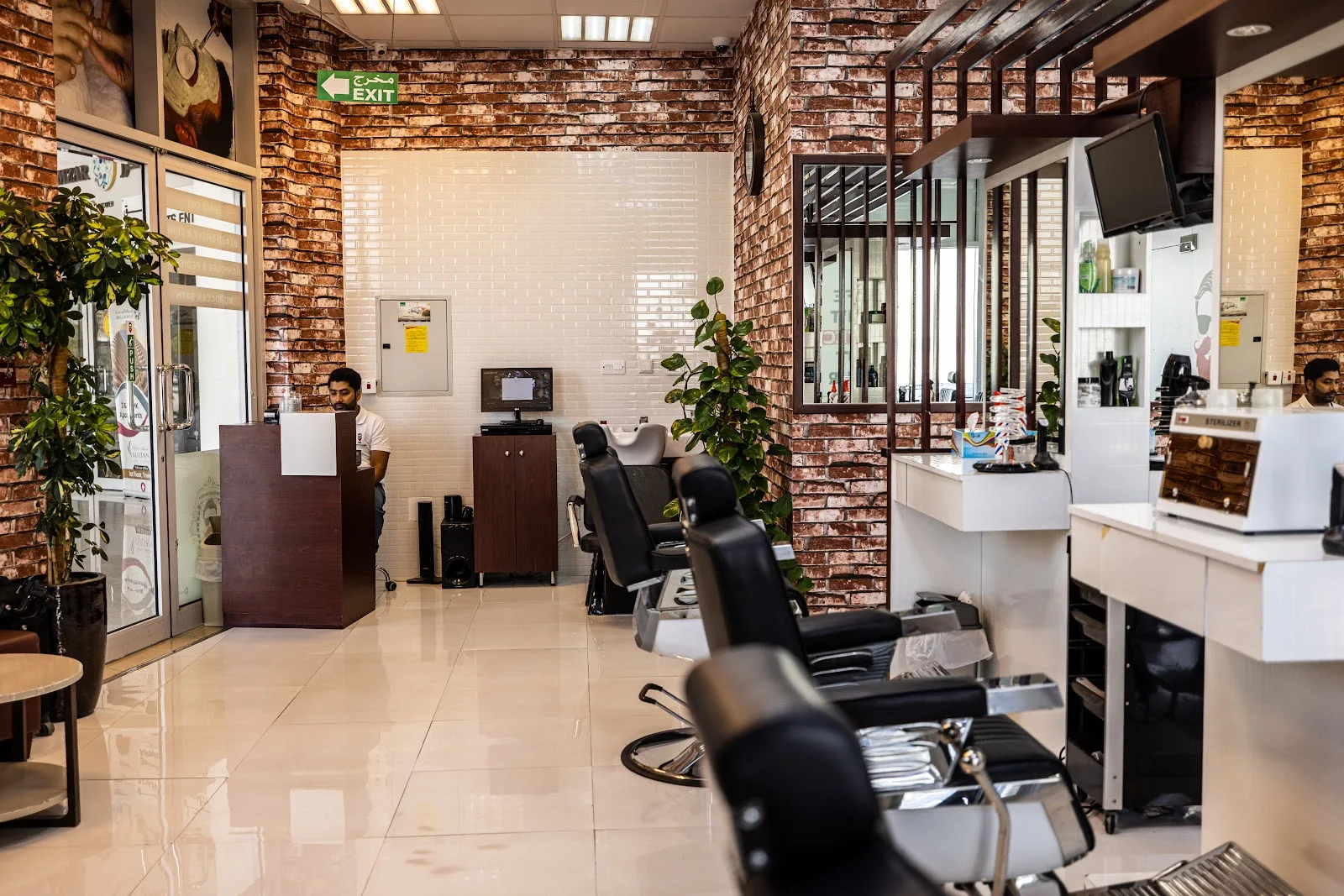 Exposed-brick interior of The Stars Barber with leather barber chairs and a reception desk