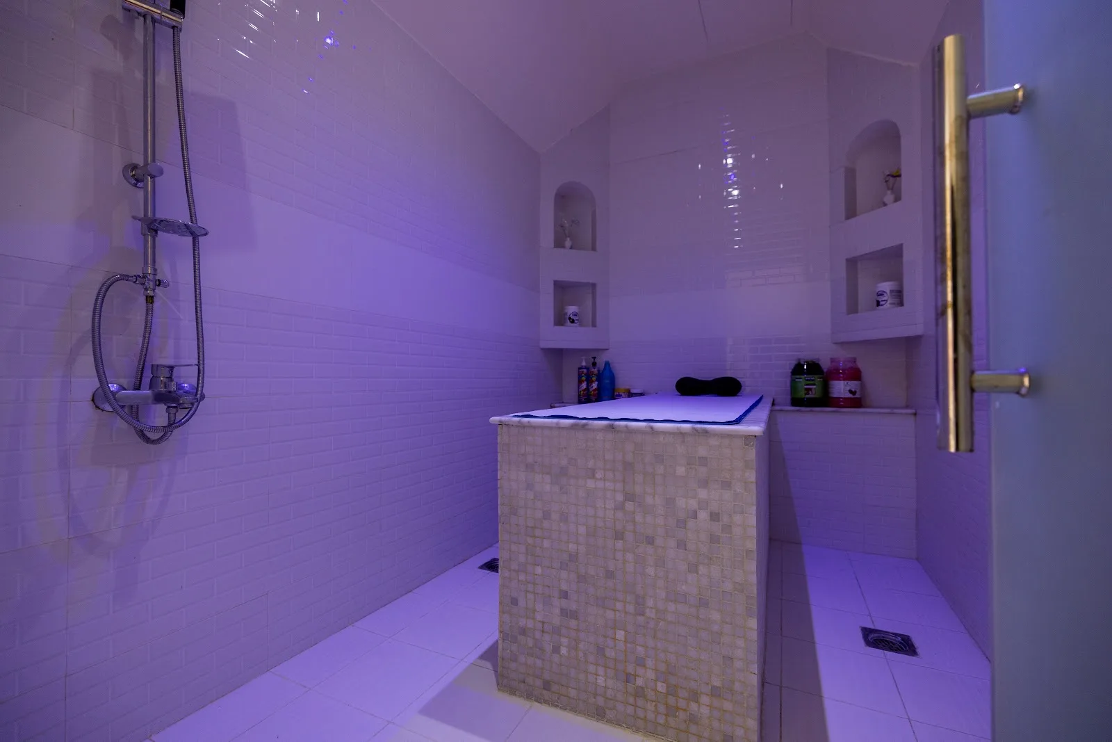 The private Moroccan bath steam room with tiled walls and a heated marble slab