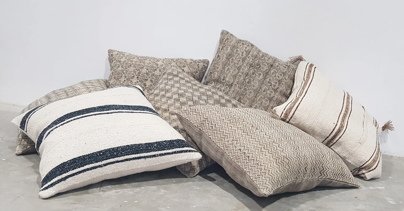 A row of neutral hand-loomed kilim cushions