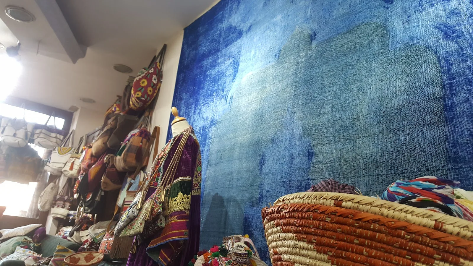 Blue overdyed rug displayed across a showroom wall