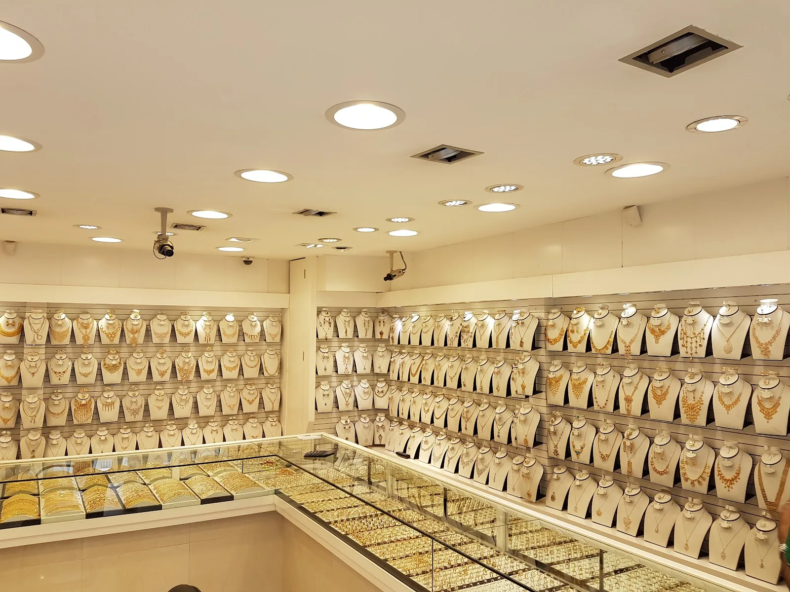 Long interior wall of gold necklace sets on white display stands
