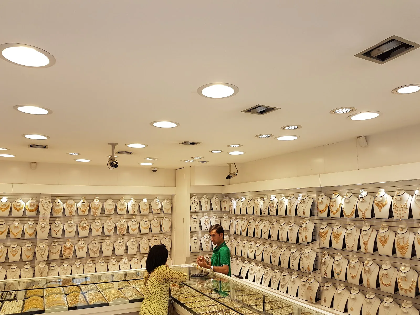 A customer being shown gold jewellery at the counter by a shop assistant