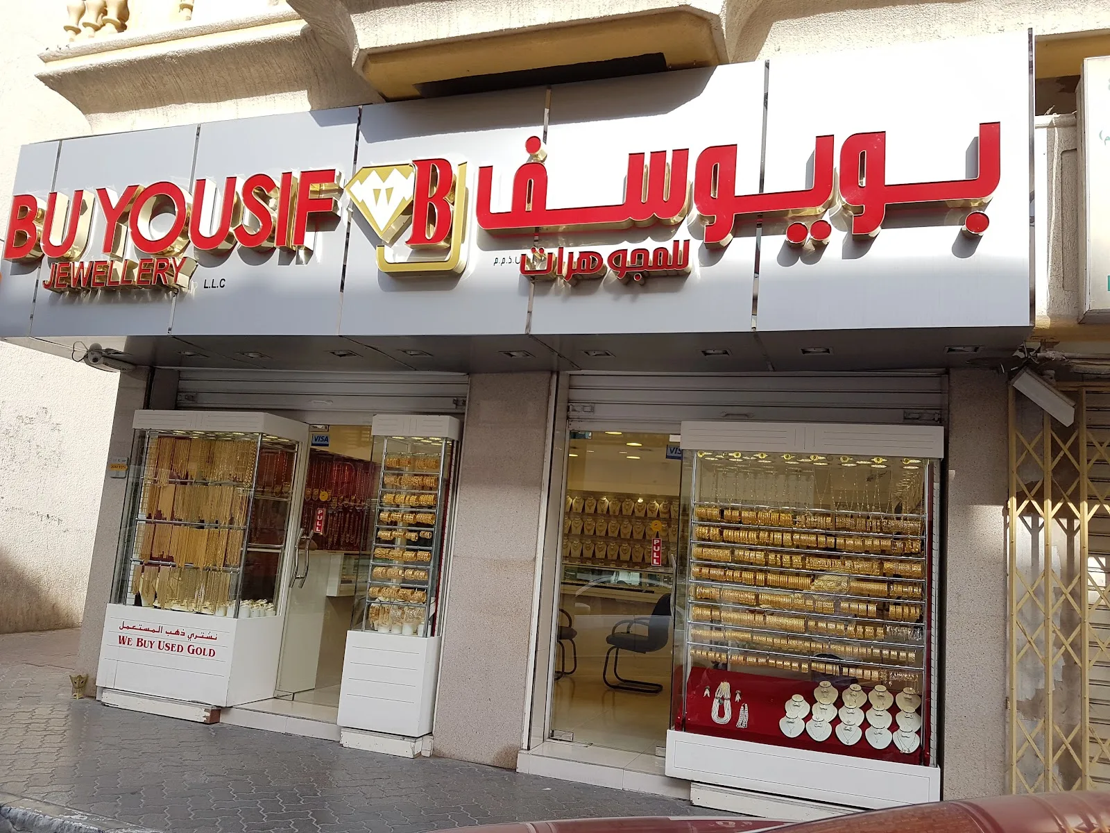 The red and gold Bu Yousif Jewellery storefront sign above the shop windows on Al Satwa Road