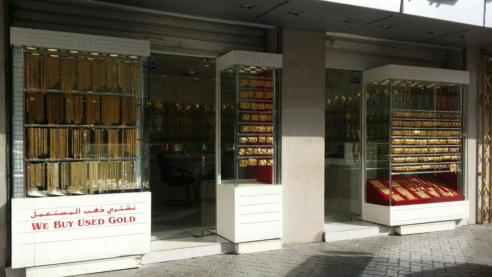 Street-facing window cases full of gold chains with a We Buy Used Gold sign